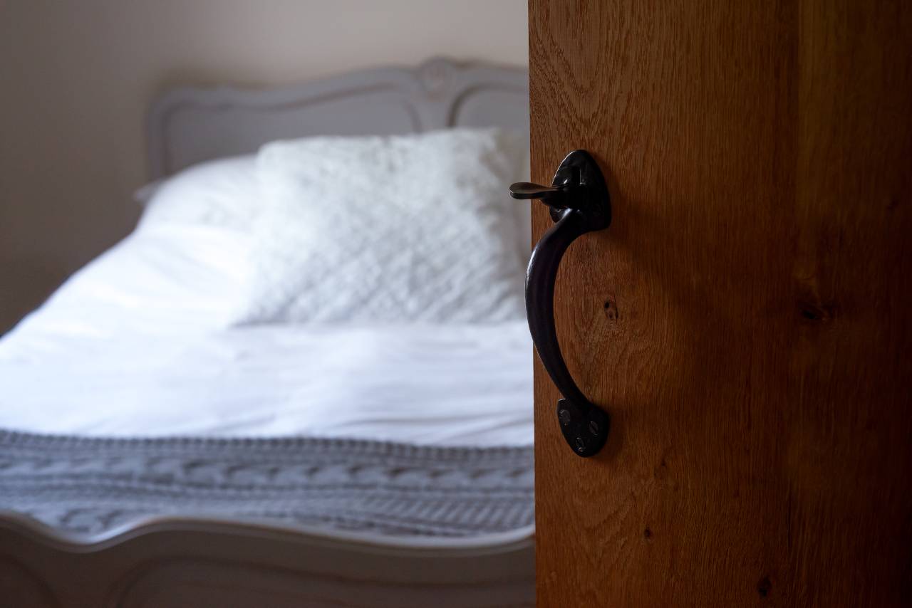 Open deur van logies met zicht op bed