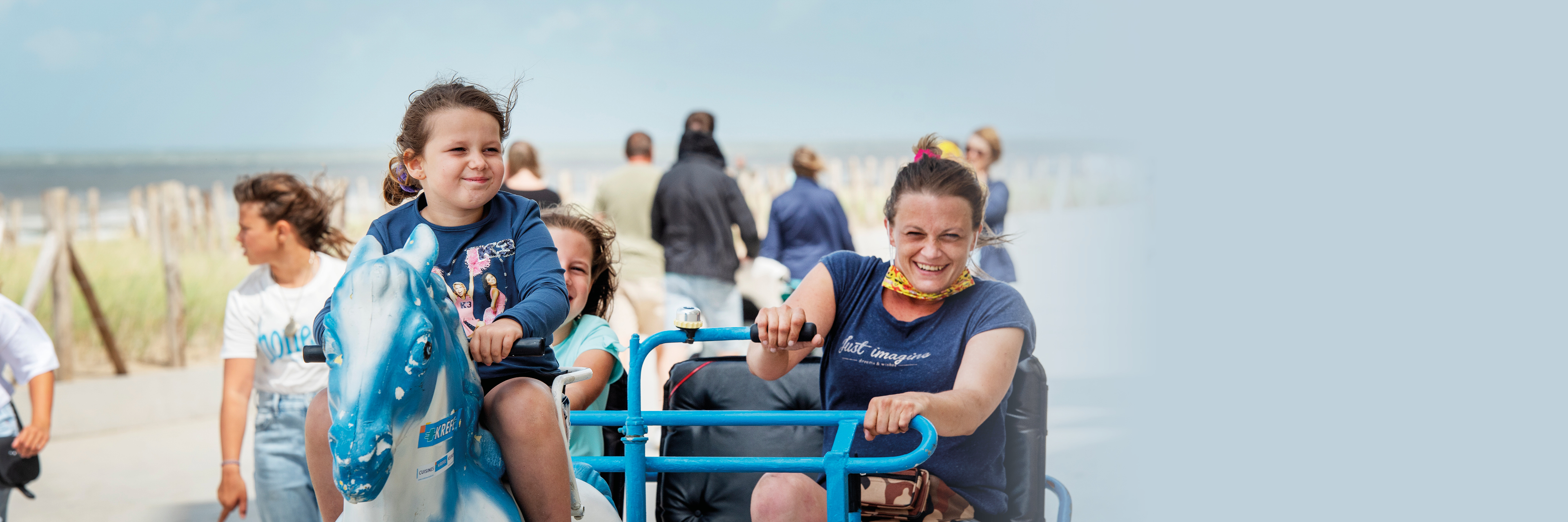 Moeder en twee kinderen rijden met go-kart op een dijk aan de Belgische kust.