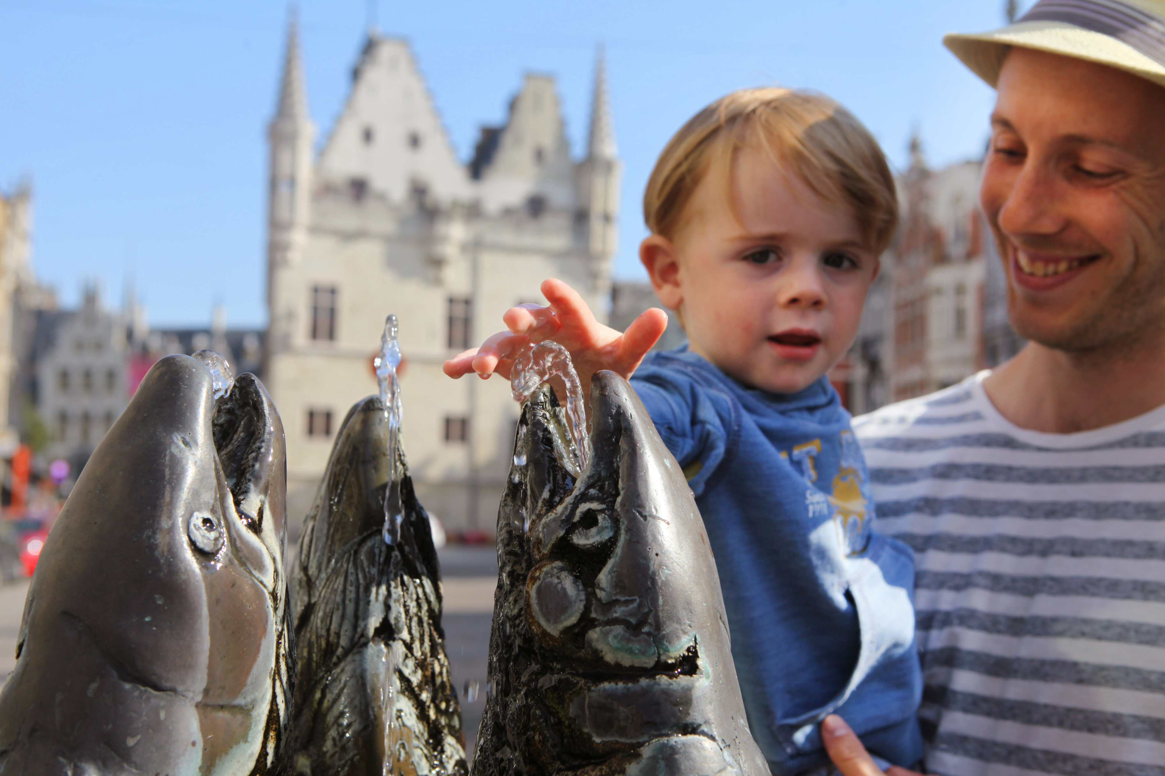 Man met kindje bij standbeeld