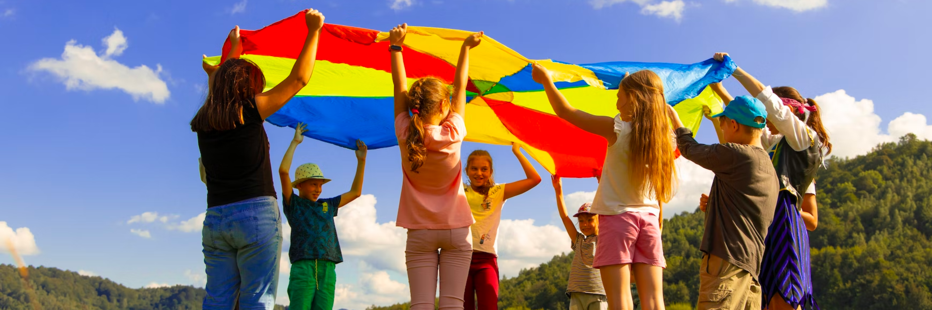 spelende kinderen in de zon met parachute doek