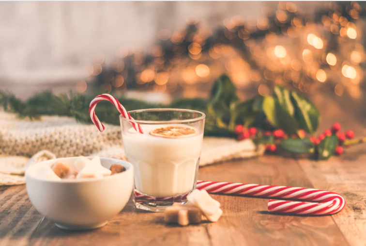 Kersttafereel met zoetigheid en kopje chocomelk op tafel