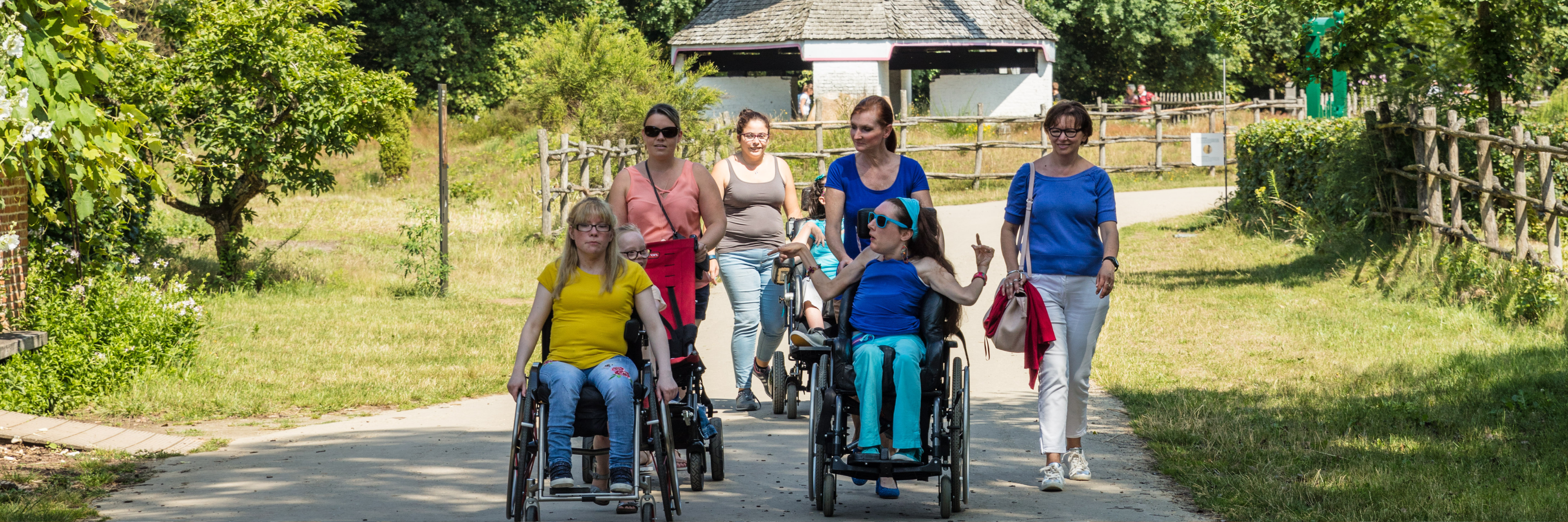 Begelide rolstoelgebruikers in het openluchtmuseum Bokrijk