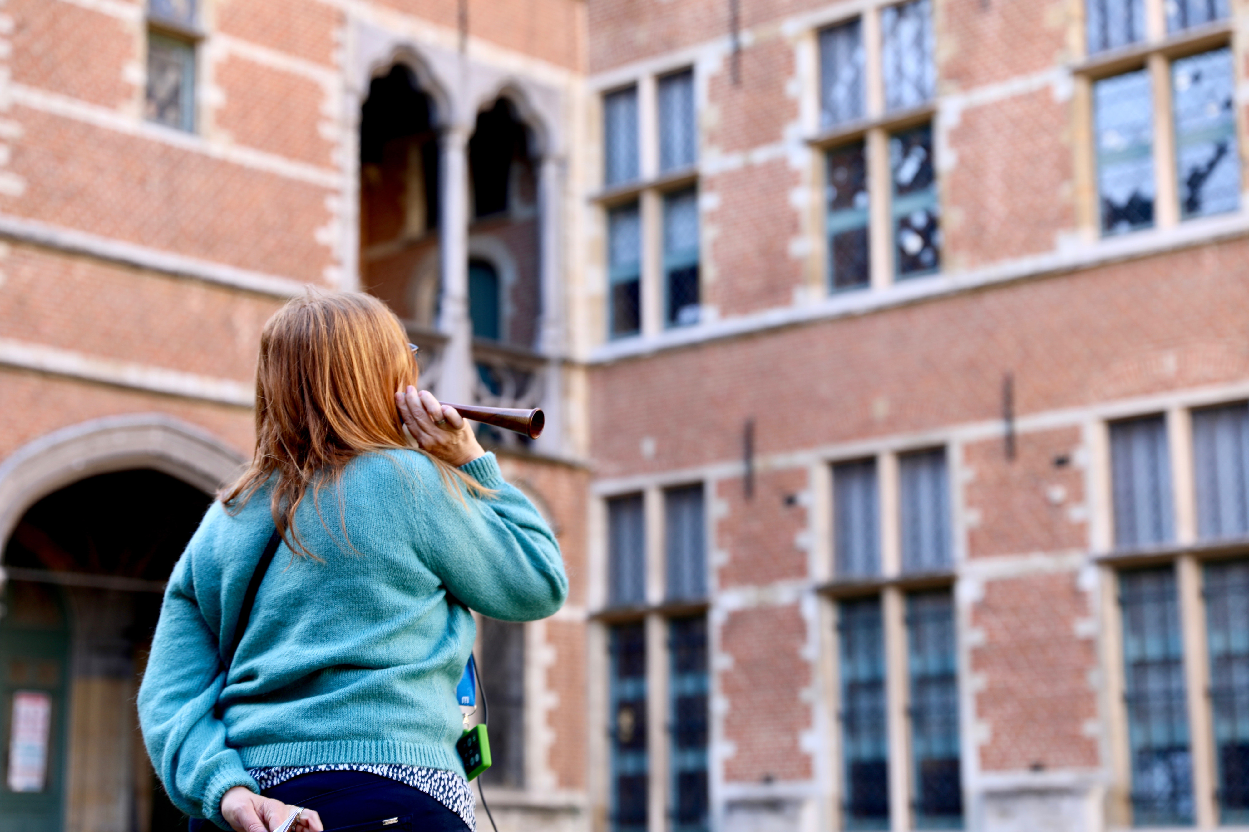 Vrouw die de luisterwandeling 'Als Muren Konden Praten' in Mechelen volgt.