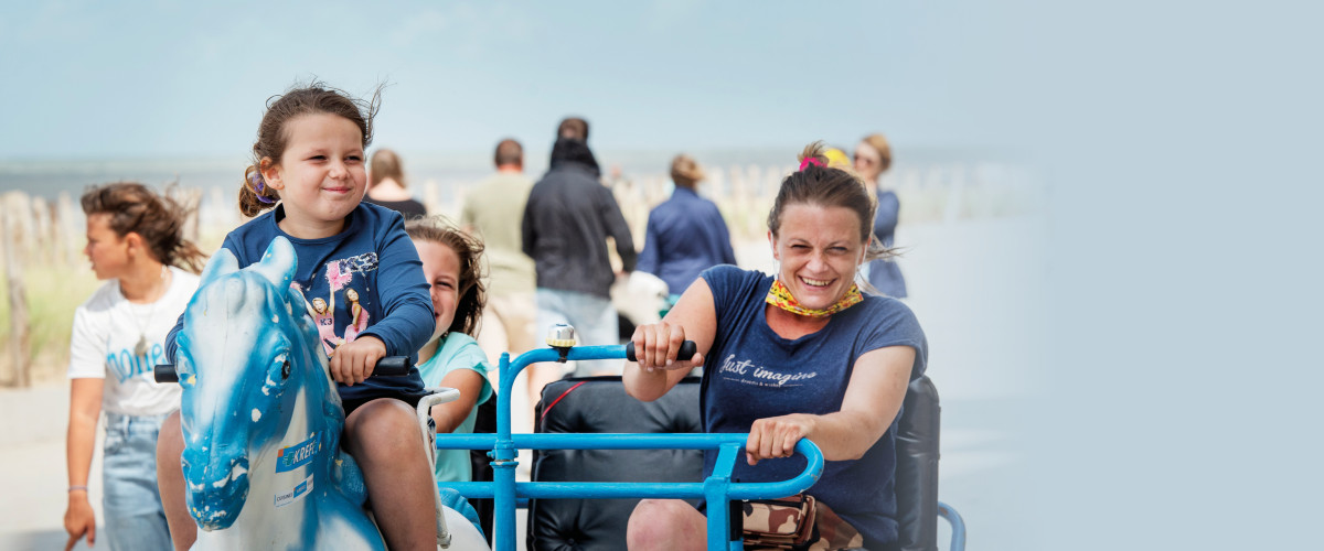 Moeder en twee kinderen rijden met go-kart op een dijk aan de Belgische kust.