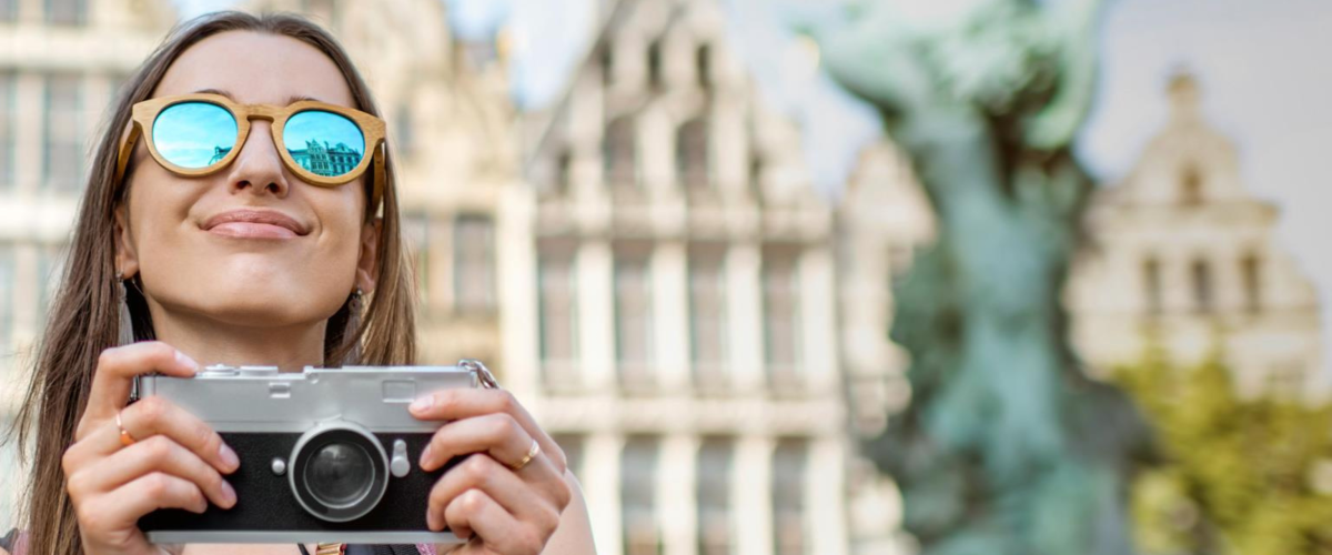 Meisje met zonnebril en camera op de Grote Markt in Antwerpen