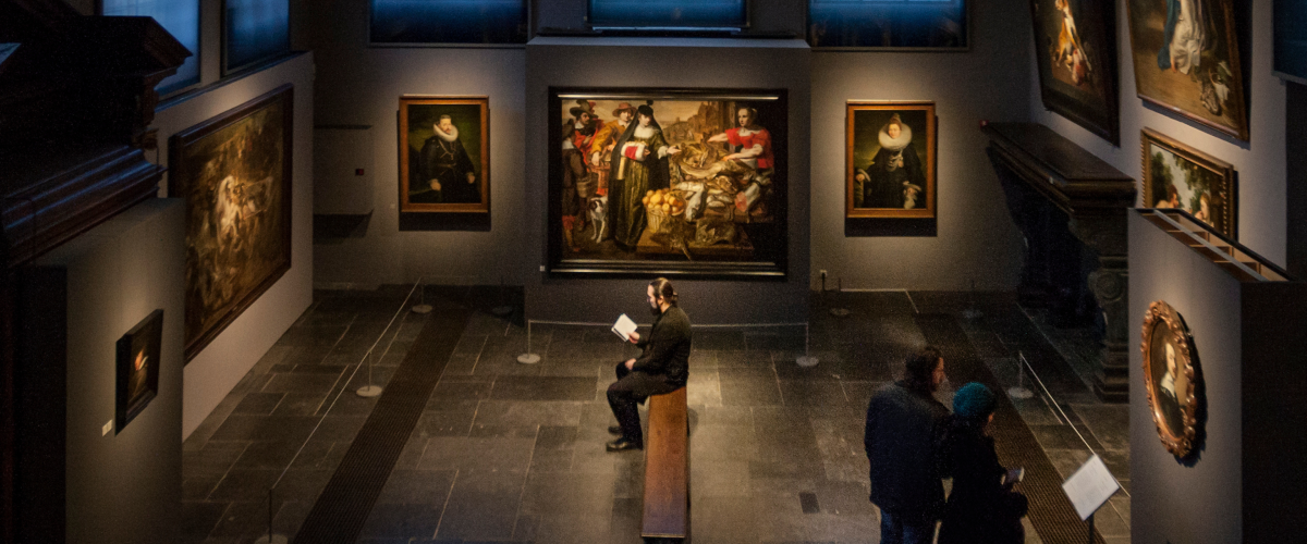 Man op bankje in museumzaal