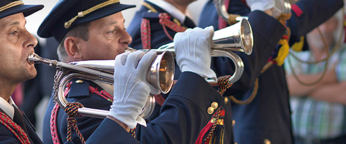 Afbeelding van mannen in uniform die trompet spelen.