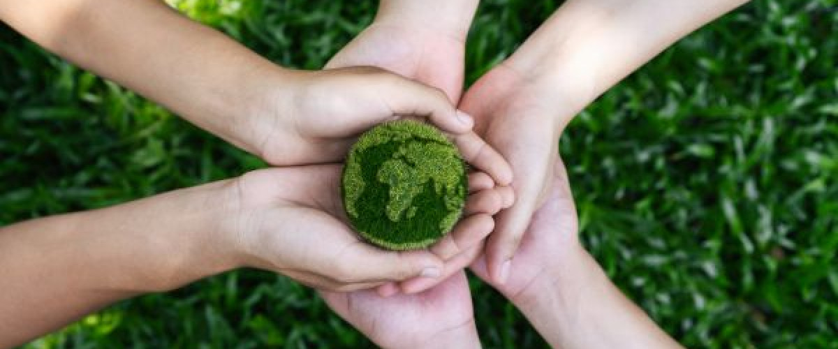 Verschillende paar handen die een groene aardbol vasthouden.